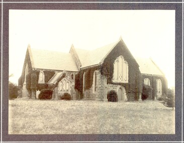 Black and white photograph of St Johns Church of England with ivy growing over the exterior 