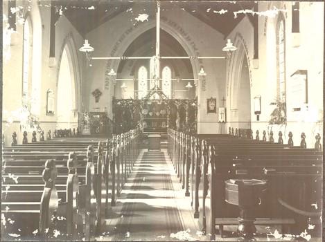 Black and white photograph of the interior of the church with gas lighting