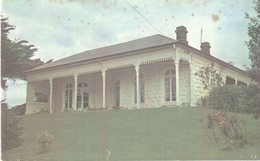 White painted stone house with bay window to right and large verandah