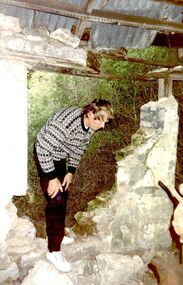 Arthur Hoey standing in a hole in the wall of the cottage