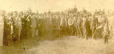 Large group of dignitaries and general public witnessing the turning of soil