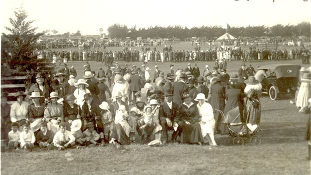 Crowds of people with cars and tent in background at Port Fairy Show Day
