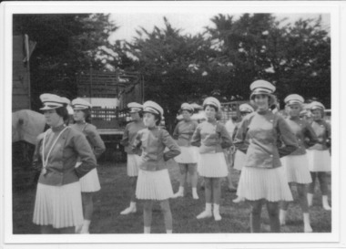 Girls in marching girl uniforms standing at ease at show grounds