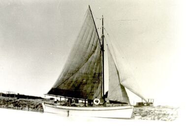 Amaryllis with her coloured sails furled near the slipway on Griffith Island