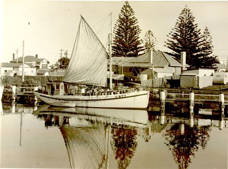 Fishing boat ‘Inverness’ with sail furled berthed at lower end of wharf
