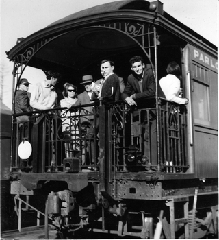 The balcony at the back of the observation train with men and children standing