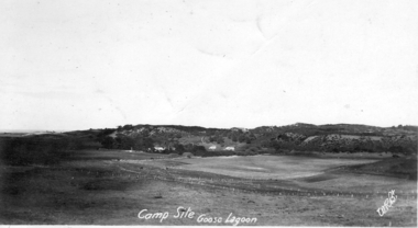 Grasslands in the foreground, three houses in hills at rear