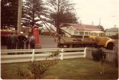 Coloured photograph of five men with a hoist  on a  truck being used to remove the red post box from Bank and William Streets