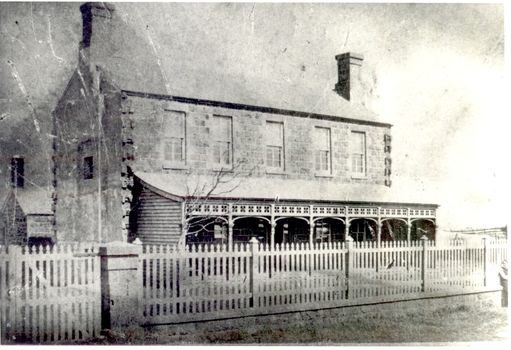 Bluestone 2 story building with verandah and paling fence