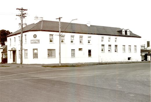 2 story building with multi paned windows power pole on corner and telegraph pole to the right