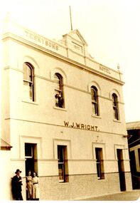 The facade of Tennyson’s hotel with a male and two females on footpath and two females at window