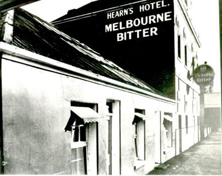 Facade of early inn and two story Tennysons hotel two prominent signs on building