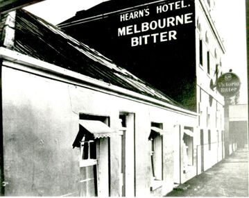 Facade of early inn and two story Tennysons hotel two prominent signs on building