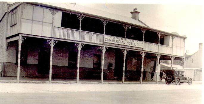 Two story bluestone painted commercial hotel with large verandah car at kerb