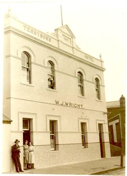 2 story building with tiled wainscoting male and 2 females in doorway and 2 females in window upstairs