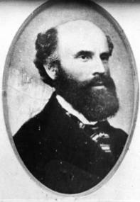 Black and white portrait of gentleman with black full beard and striped cravat