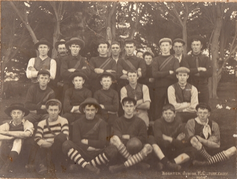 Formally posed group of male footballers with trees in background