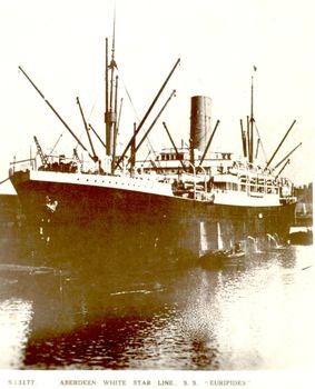 Ship with many derricks and a small boat at her side