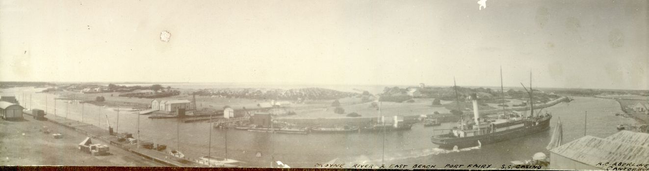 Slightly distorted view of  s.s.Casino leaving the wharf and sailing towards the entrance to the river Moyne, buildings on the East side of the river, dredges and barges are visible in centre of photograph 