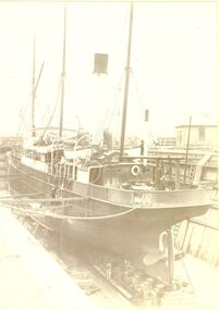 S.s.Casino in dry dock with a man working on a ladder on the left side of the ship