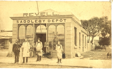 4 males standing outside a shop with 5 arched windows