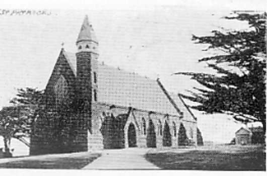 Church on a rise with a spire to the right of the front entrance on right with three buttresses along side