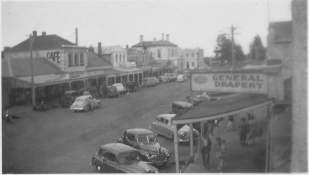 Centre of Sackville street, general Drapery sign on right and cafe sign on building on the left