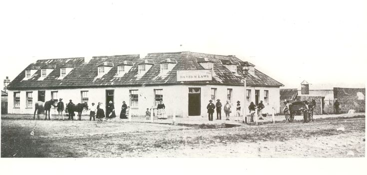 Black and white photograph of the Caledonian Inn with people on streets outside