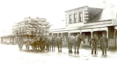Wagon loaded with bales of wool, five horses and two men in Sackville Street in front of Cheapside Warehouse.