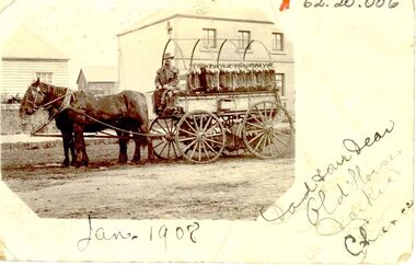 Wagon load of rabbits with two horses man on seat and two story house behind 
