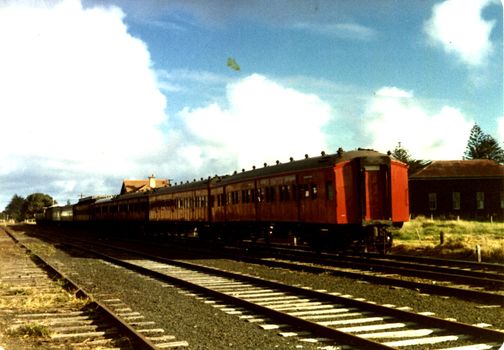 Port Fairy train at station with several red carriages three rail lines in foreground