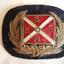rectangular hat badge with gold laurel leaves embracing the red and white flag of the Belfast and Koroit Steam Navigation Company
