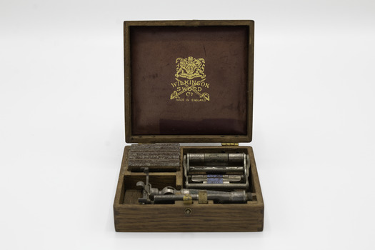 Open box with all elements of the razor in their compartments and showing the manufacturer’s label on the inside lid