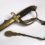 Detail of handle,decorative engraving on upper end of scabbard, and rope and tassel at the top of the sword