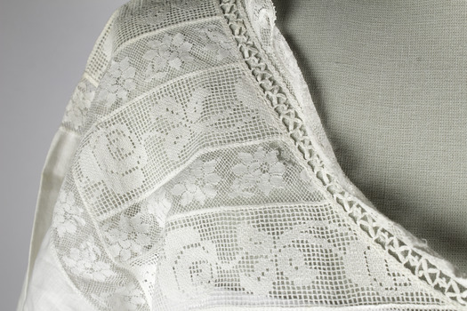 Detail of neckline showing lace,embroidery and frill