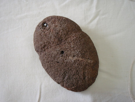 Showing a hole which has been cut through top of hammer or axe