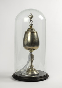 Trophy with blue ribbon attached encased in a glass bell case