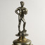 Detail of the footballer figure on the top of the trophy holding a round ball and wearing a cap