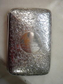 Top of silver cigar case with embossing and engraving