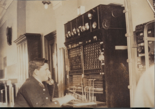 A male taking a call at the desk of the Port Fairy telephone exchange