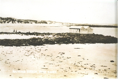 Stone reef with bathing boxes perched on top with two people on the left