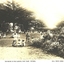 Several groups of adults and children sitting on the mound in the gardens