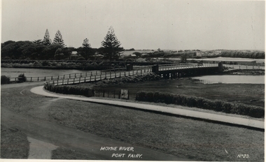 Road leading to Moyne traffic bridge on West side of river with botanical gardens in background left