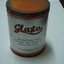 Round tin with orange lid and band around base made to hold milk powder for infants