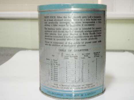 Back of milk powder tin with blue markings with a table of quantities for feeding to infants