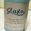 Front of round, blue and grey milk powder tin marked progressive milk food for older infants