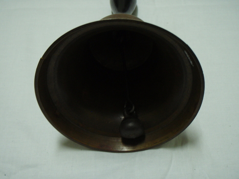 inside of bell showing brass round clapper on chain