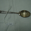 teaspoon with a figure of a golfer engraved in the bowl and two golf clubs forming the handle 