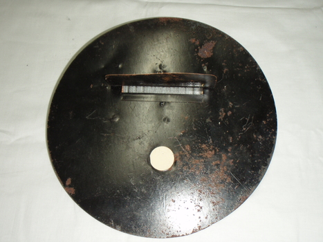 Metal circle with round attachment hole and long slit with a cover and wire barrier