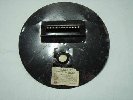 metal circle with light slit and round hole for attachment and paper label of instructions on how to use